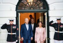 Joe Biden and Kamala Harris exit building with guards.