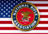 National Rifle Association logo on American flag background.