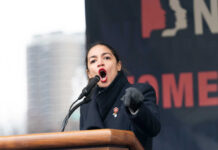 Alexandria Ocasio-Cortez passionately speaking at a podium outside.