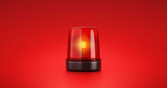 Red emergency light flashing on a red background.