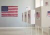 Polling booths with American flags and Vote signs.