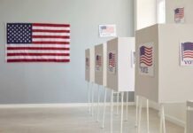 Polling booths with American flags and Vote signs.