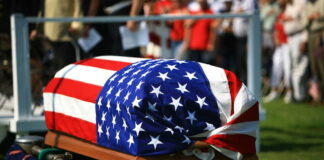 Coffin with American flag on it.