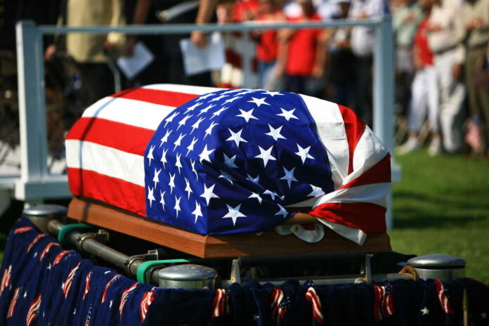 Coffin with American flag on it.