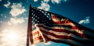 American flag waving against a bright sky.