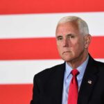 Mike Pence against flag backdrop.