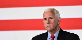 Mike Pence against flag backdrop.