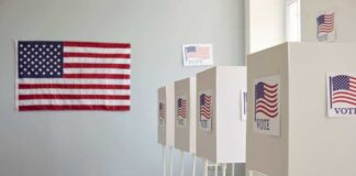 Polling booths with American flags and Vote signs.