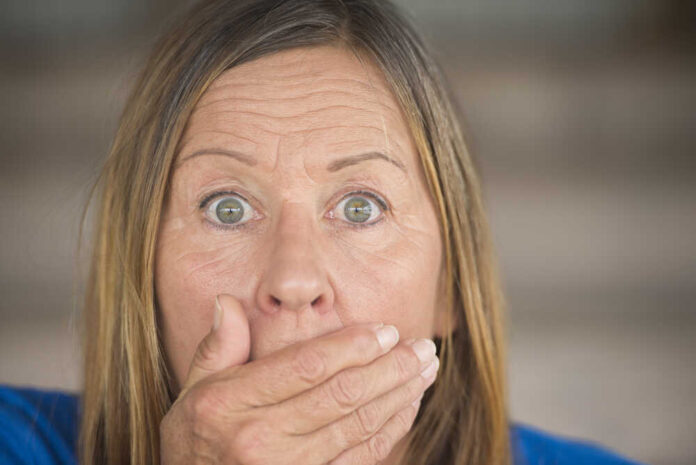 Surprised woman covering her mouth with hand.