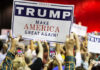 People holding Trump Make America Great Again signs.