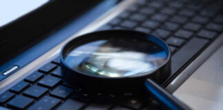 Magnifying glass on a laptop keyboard.