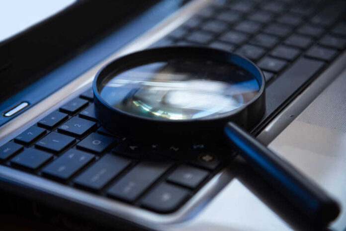 Magnifying glass on a laptop keyboard.