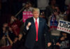 Donald Trump at a rally, surrounded by supporters.