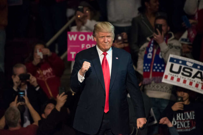 Donald Trump at a rally, surrounded by supporters.