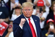 Donald Trump at a rally, raising his fist.