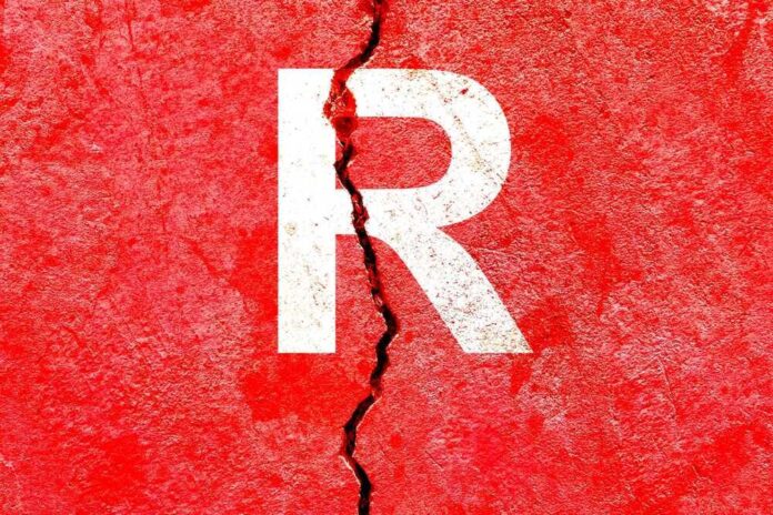 Cracked red wall with white letter R.