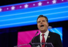 Person speaking at podium in front of colorful background