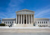 U.S. Supreme Court building under clear blue sky.