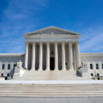 U.S. Supreme Court building under clear blue sky.