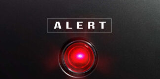 Red alert light against black background, text ALERT.