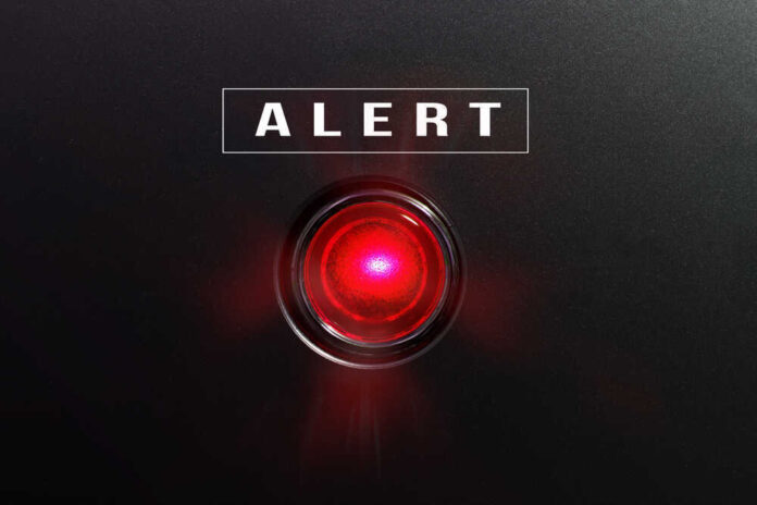 Red alert light against black background, text ALERT.