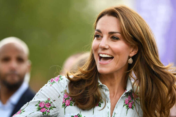 Kate Middleton in a floral blouse outdoors.