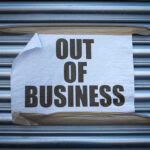 Out of Business sign on closed store shutters.