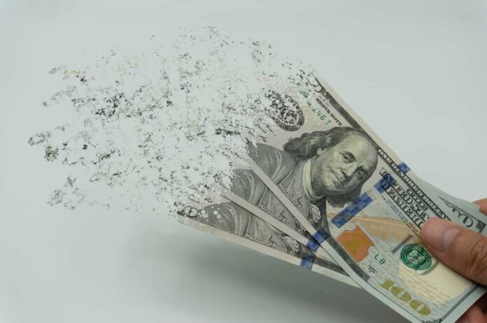 Hundred-dollar bills disintegrating in hand.