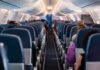 Airplane interior with passengers seated mid-flight.