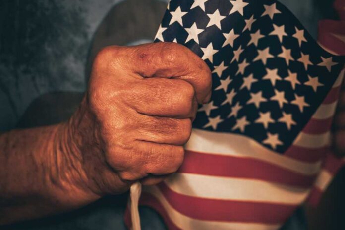 Hand holding small American flag tightly.