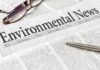 Newspaper headline reads "Environmental News," with glasses nearby.