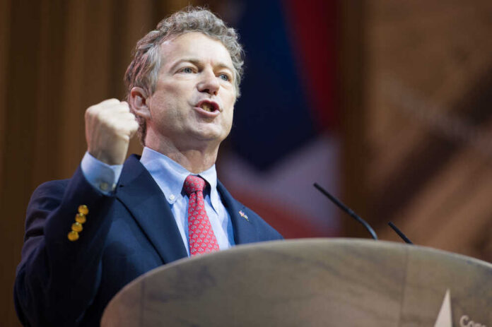 Rand Paul giving a passionate speech with fist raised.