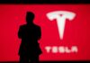 Silhouette with Tesla logo in red background.