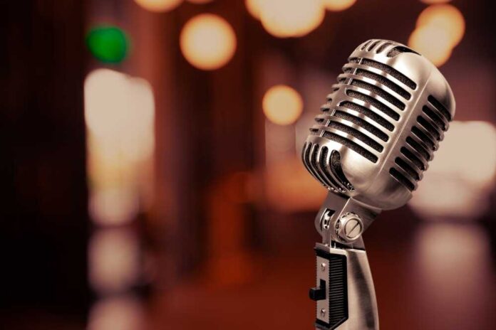 shutterstock_2337165521.jpg featured image Retro microphone with blurred background lights.
