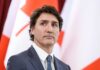 Canadian Prime Minister Justin Trudeau in suit with red and white flags