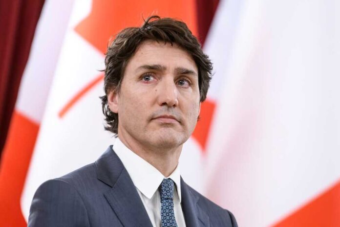 Canadian Prime Minister Justin Trudeau in suit with red and white flags