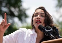 Alexandria Ocasio-Cortez speaking at an outdoor event.