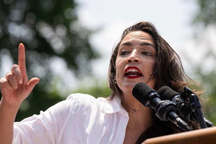 Alexandria Ocasio-Cortez speaking at an outdoor event.