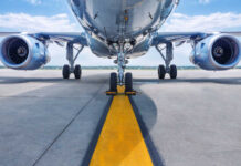 Airplane on runway with visible landing gear engines