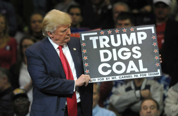 shutterstock_1427778647.jpg featured image Donald Trump holding sign saying Trump Digs Coal