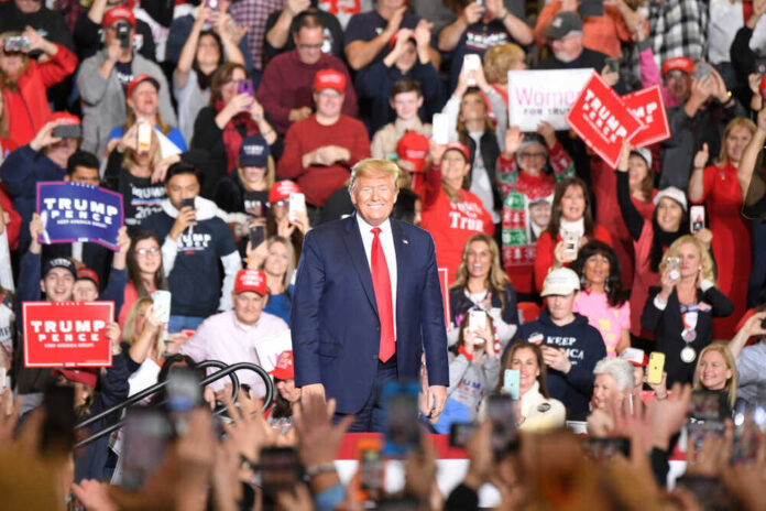 shutterstock_1629770143.jpg featured image Man in front of rally crowd smiling at camera.