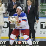 Alexander Ovechkin, hockey player celebrating with trophy on ice rink