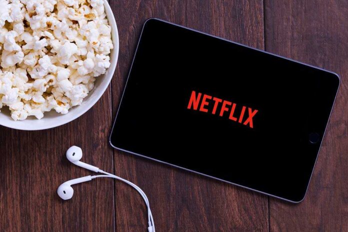 1200786709 featured image Popcorn, tablet displaying Netflix, and earphones on table.