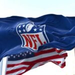 NFL flag waving beside American flag.
