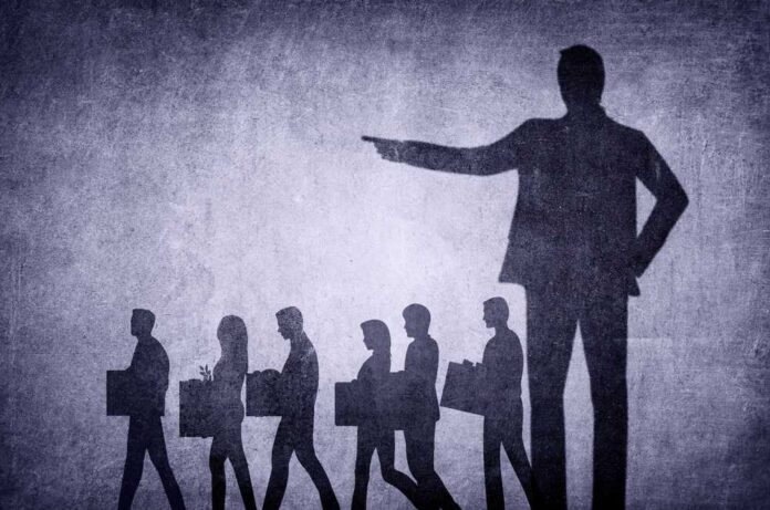 shutterstock_2254036017.jpg featured image Shadows of laid-off workers walking, large figure pointing.