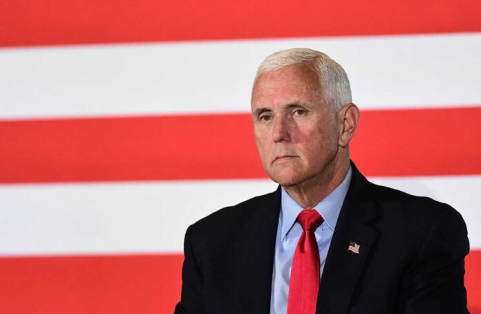 shutterstock_2358120659.jpg featured image Mike Pence against flag backdrop.