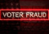 Neon sign reading Voter Fraud on American flag background.