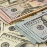 Stacks of US dollars featuring Benjamin Franklin and Ulysses S. Grant.