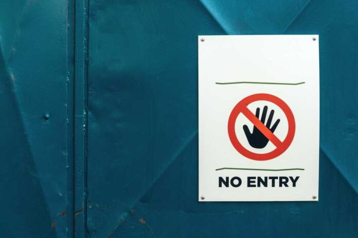 shutterstock_2244348215.jpg featured image No entry sign on teal metal door background