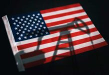 American flag with oil pump shadow overlay.